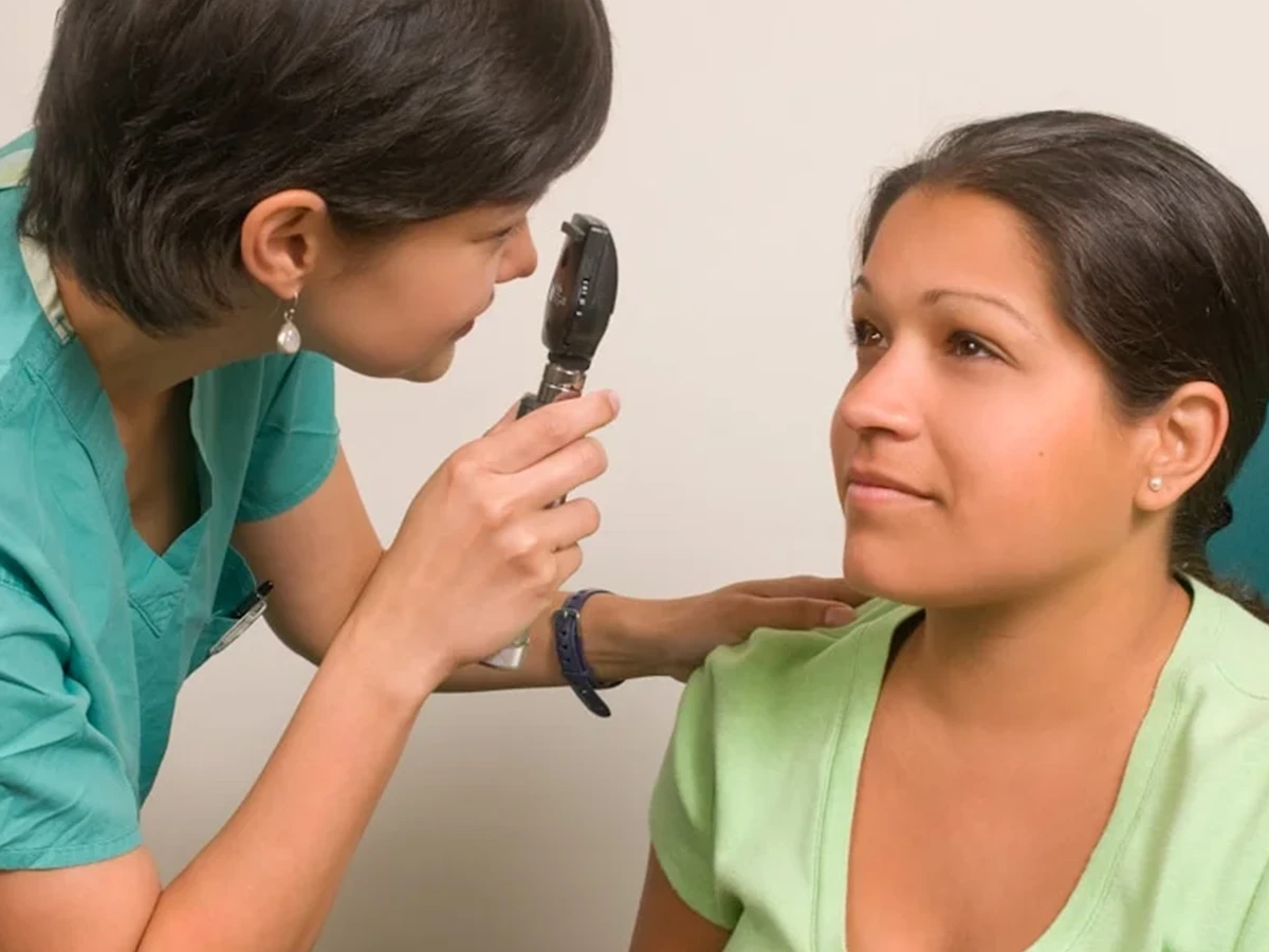 a woman sitting in a chair while a woman combs her hair
